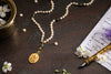 Saraswati Pendant Japa Mala18 kt Gold Pearl with Emerald Counterbead.